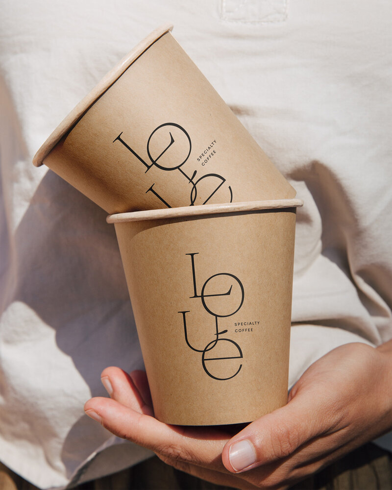 Loué Coffee Branding op Kartonnen Bekers | Minimalistisch Design