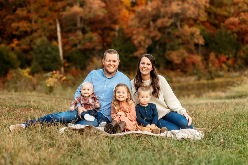 Cheerful family portrait featuring young children having fun in Knob Noster State Park, captured by Brittany Jewell Photography.