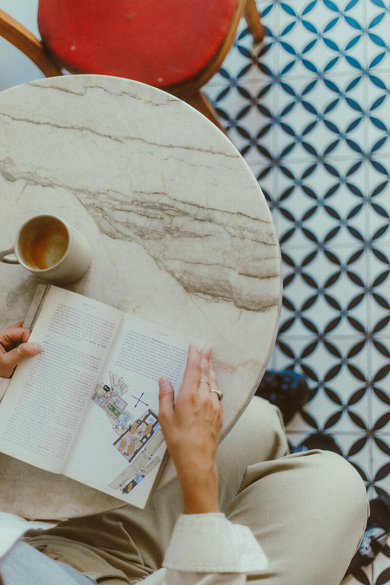 hang flipping through a book in a coffee shop