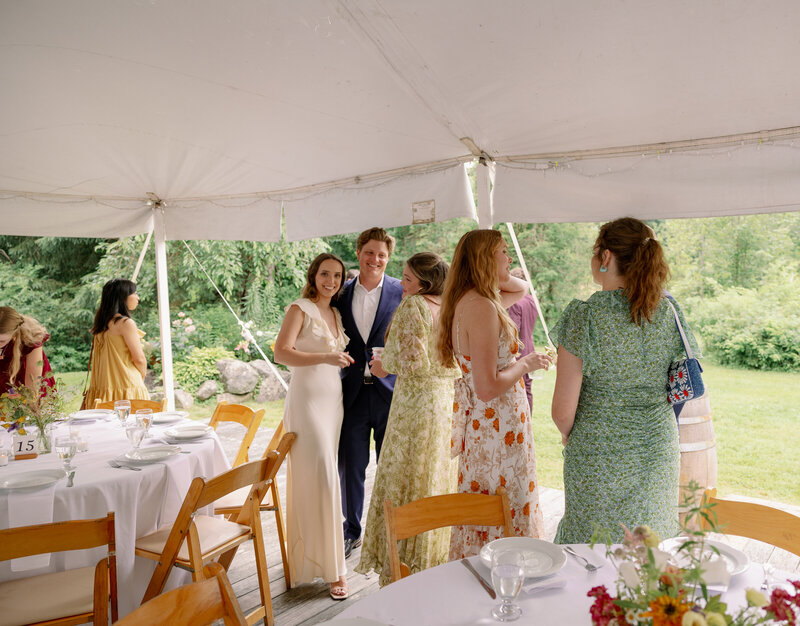 Outdoor wedding reception under a tent with string lights at dusk in Maine, York Golf and Tennis Club