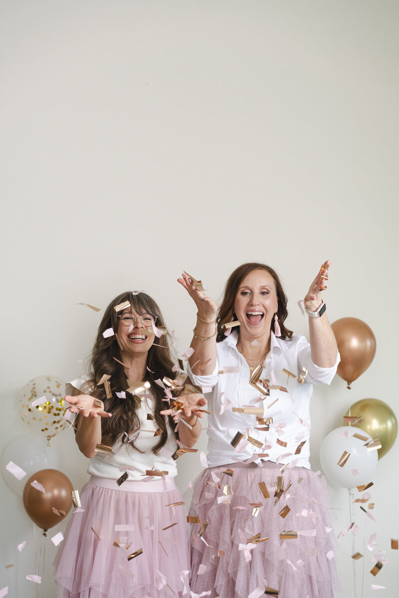 women-laughing-with-confetti-and-balloons-for-brand-photo