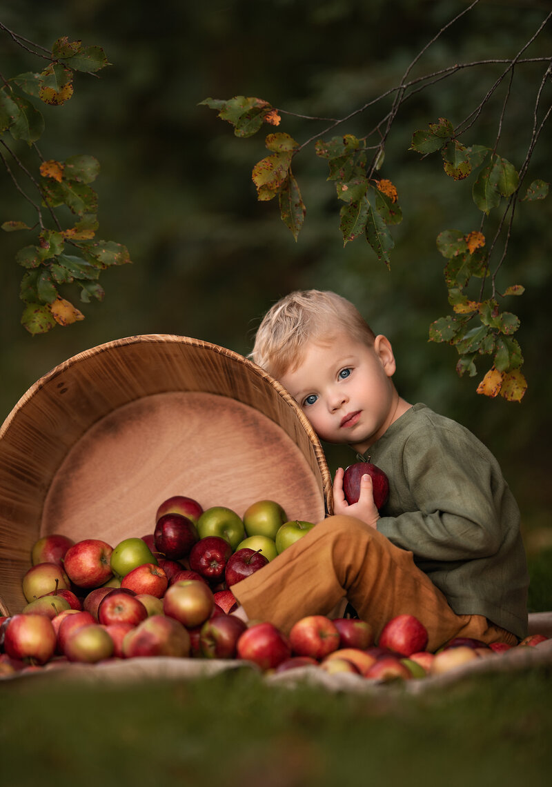 Stunning photo of a boy in an apple orchard by Iya Estrellado, a Virginia Beach photographer.