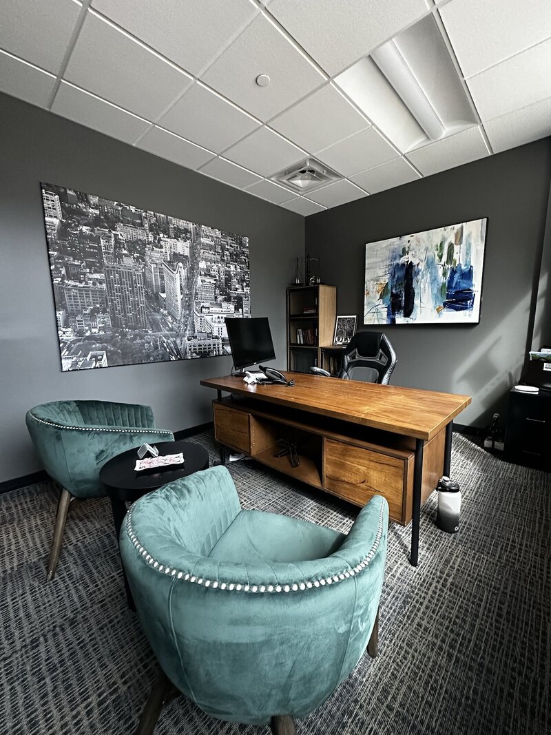 Office with green chairs and a wooden desk.