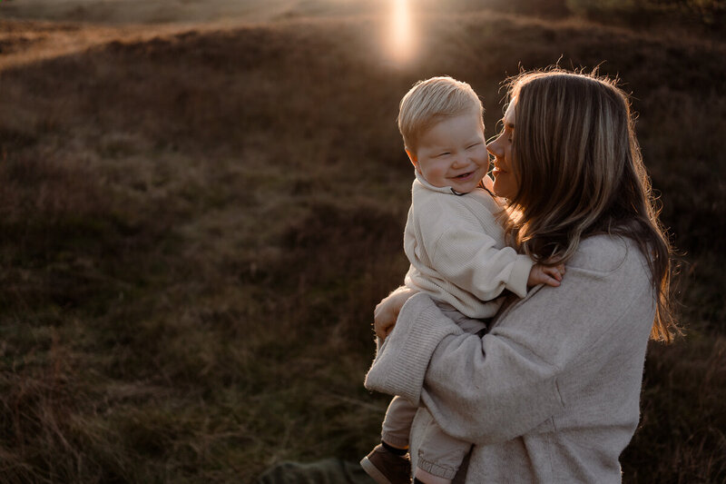 Moeder en zoon knuffelen tijdens een fotoshoot met zonsondergang