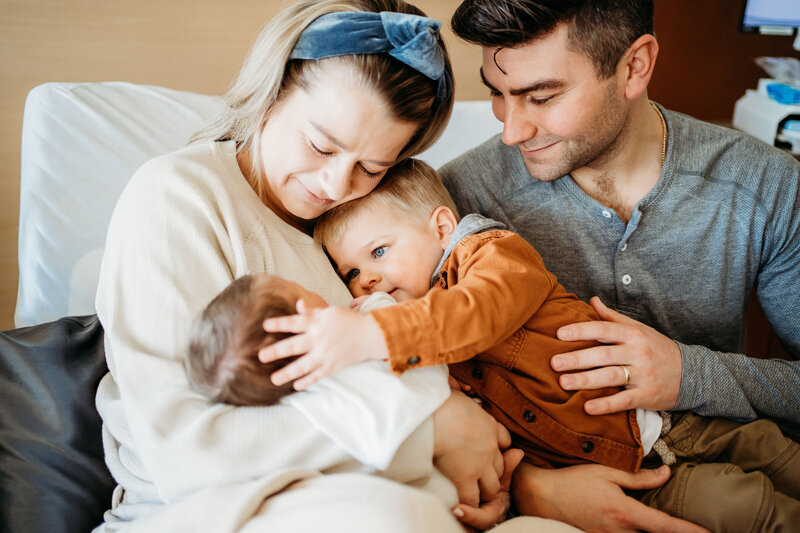 Family cuddling with newborn in hospital