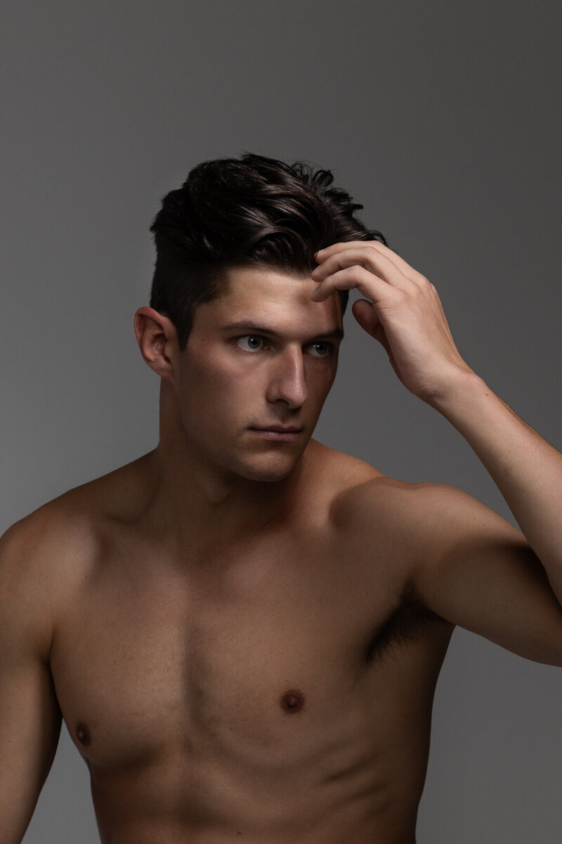 main without shirt touching his hair