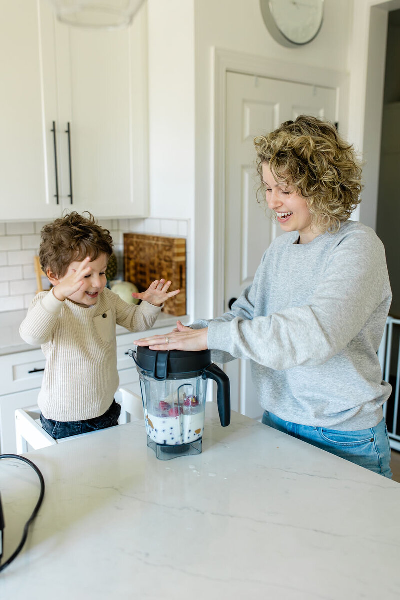toddler helping mom make smoothie