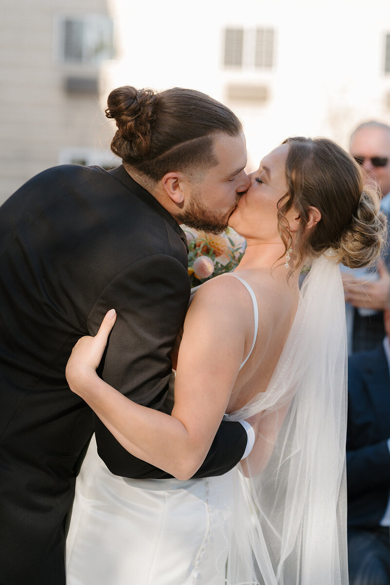 couples first kiss during wedding ceremony at Stoneycreek hotel in Lacrosse Wi.