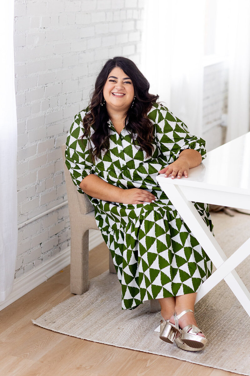Marissa Martinez in green dress sitting at a writing desk