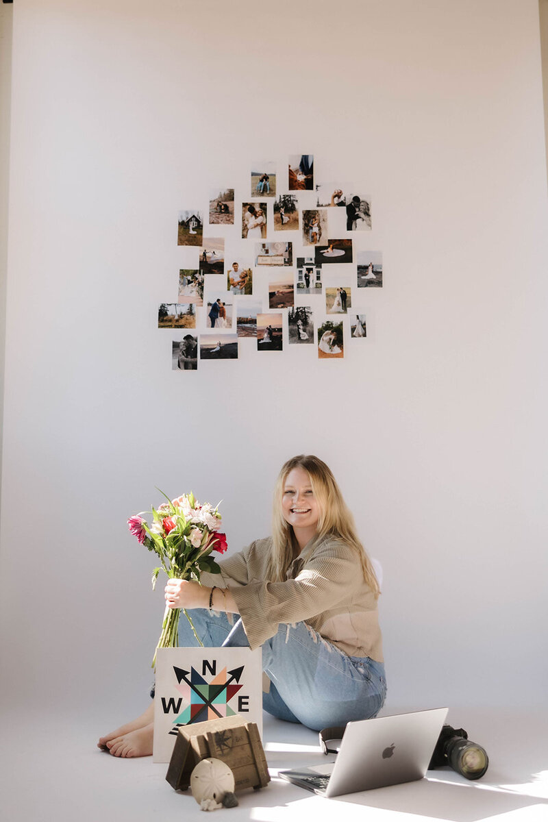 Elopement Photographer smiles surrounded by meaningful items that inspire her creativity and storytelling.