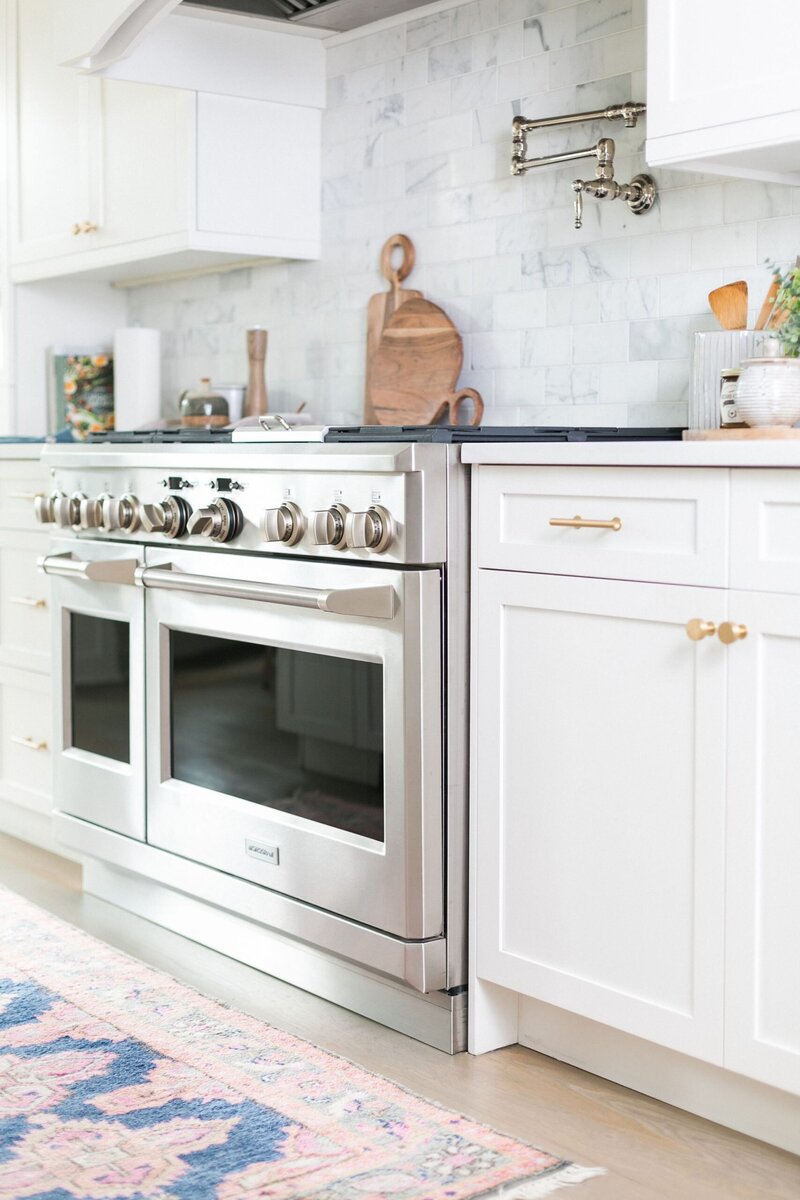 White Kitchen detail shot with brass hardware and stainless steel appliances