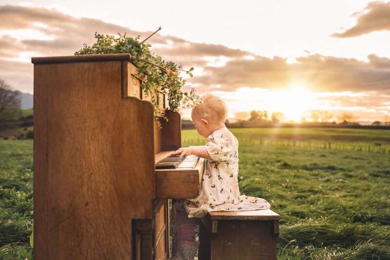 beautiful sunset with a toddler playing the piano in a paddock