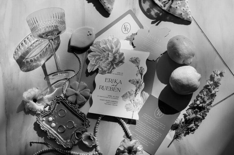 Flat lay of beauty products with floral designs, glass bottles, fresh lemons, and dried flowers arranged artfully on a white surface, perfect for bridal preparation or wedding day styling photography in Portland, Oregon or destination settings.