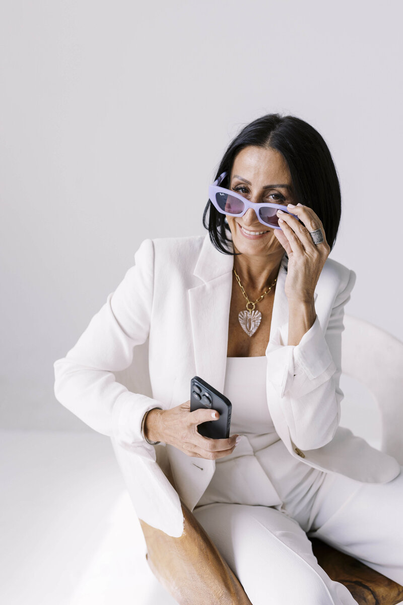 Monitization strategist, Tarah Baiman, wearing white suite and purple sunglasses