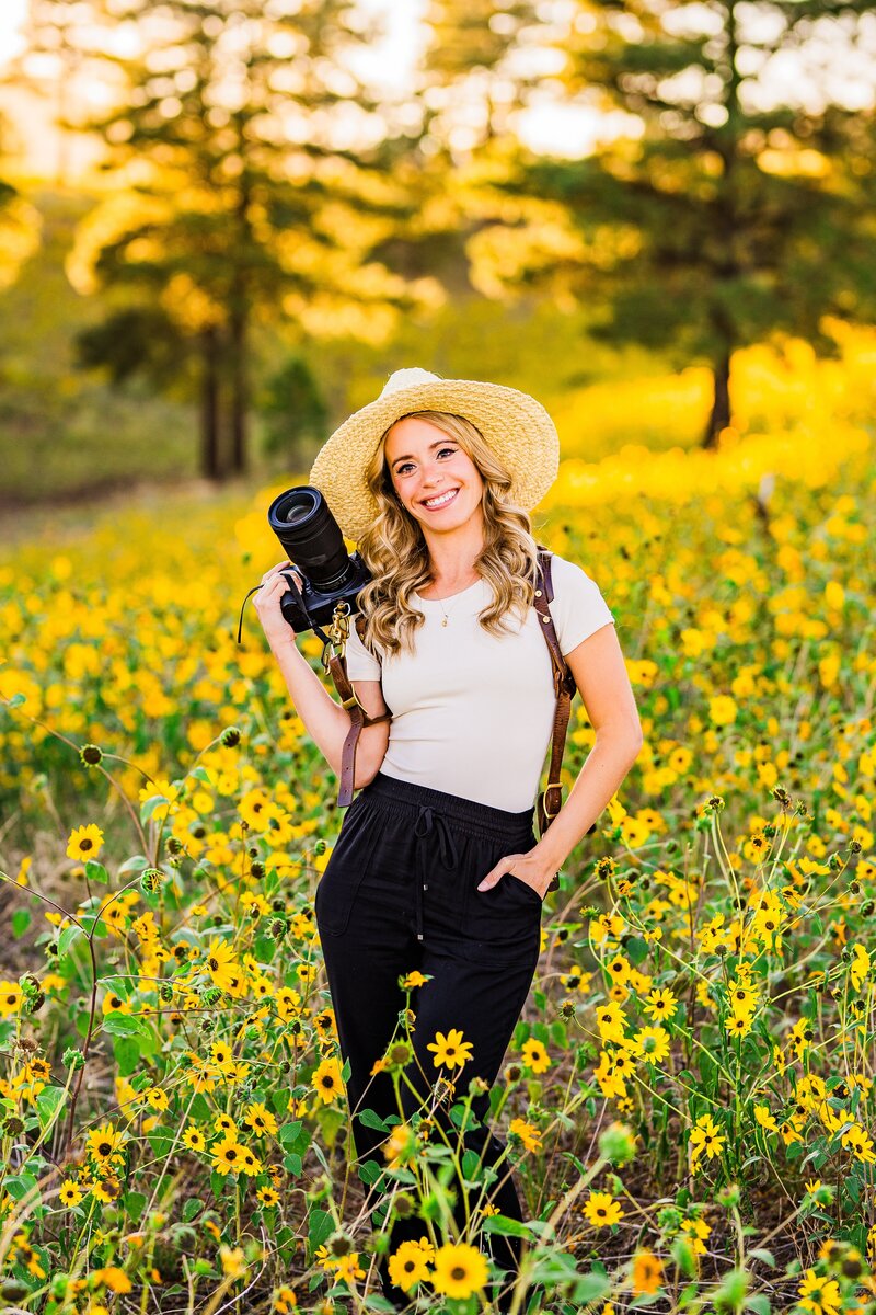 Julia Romano Photography portrait and wedding photographer sunflowers field Flagstaff holding camera