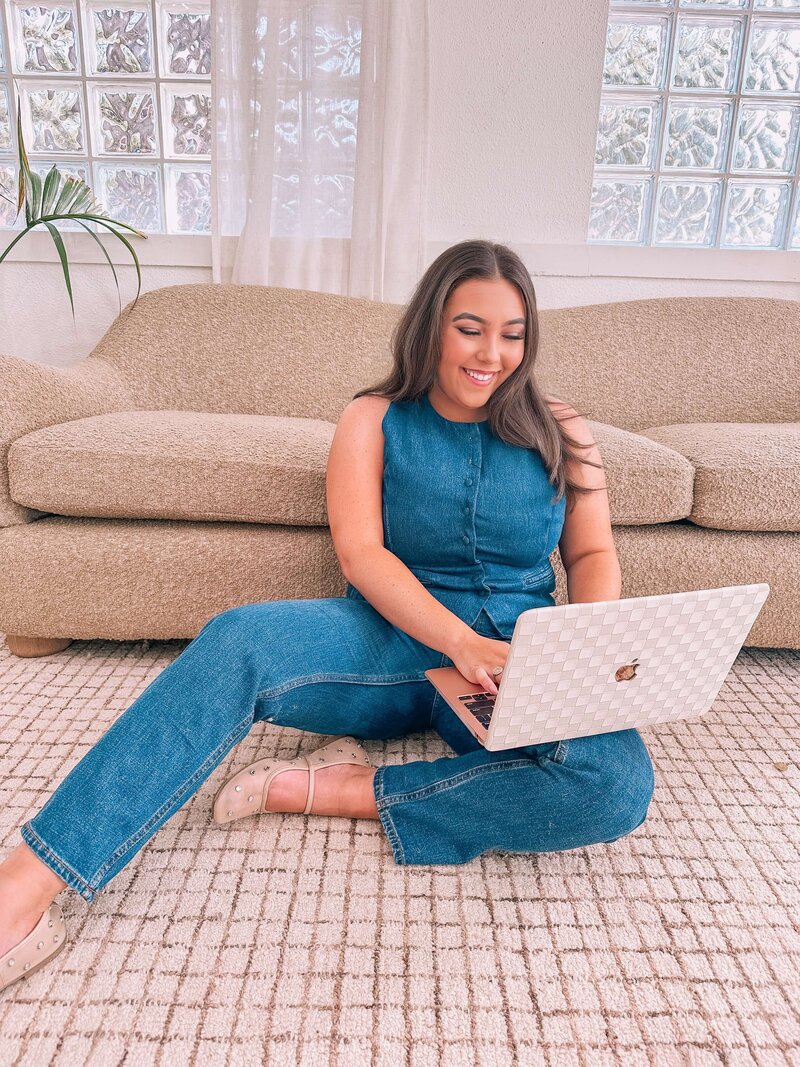 Natalie sitting on the floor with a laptop