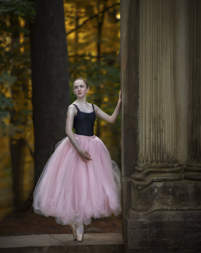 : "A young ballerina captured in a beautiful fall outdoor setting, with vibrant autumn leaves and soft natural light, showcasing the grace and beauty of ballet in Ottawa."