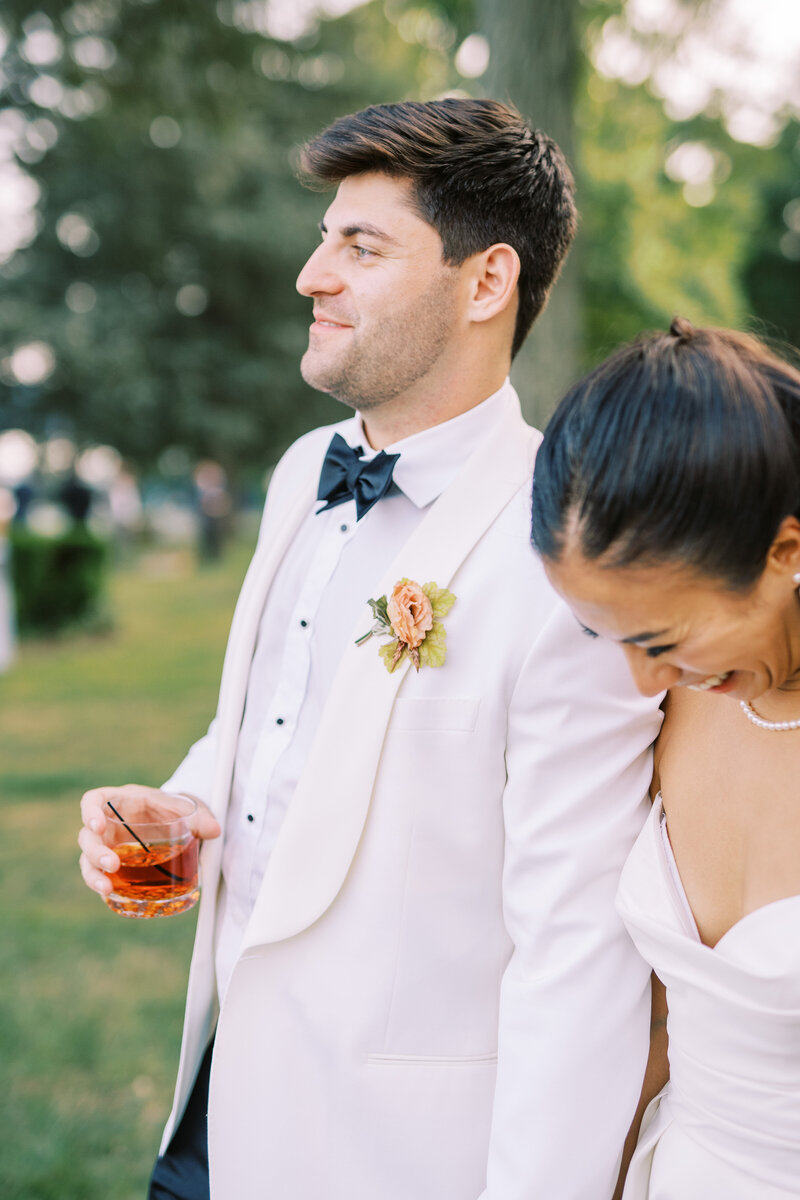 Groom holding a drink at cocktail hour at Glen Foerd Estate in Philadelphia, PA