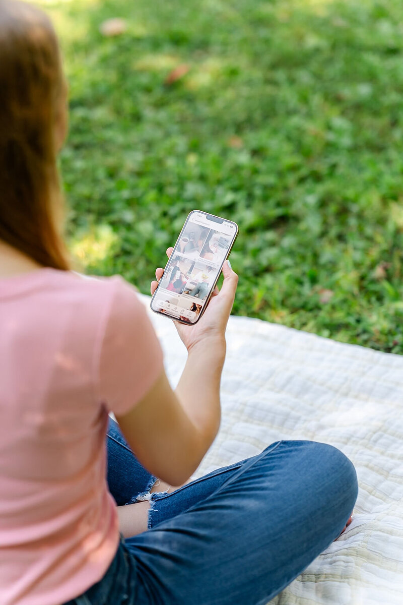 Virtual assistant using her phone to scroll on Pinterest