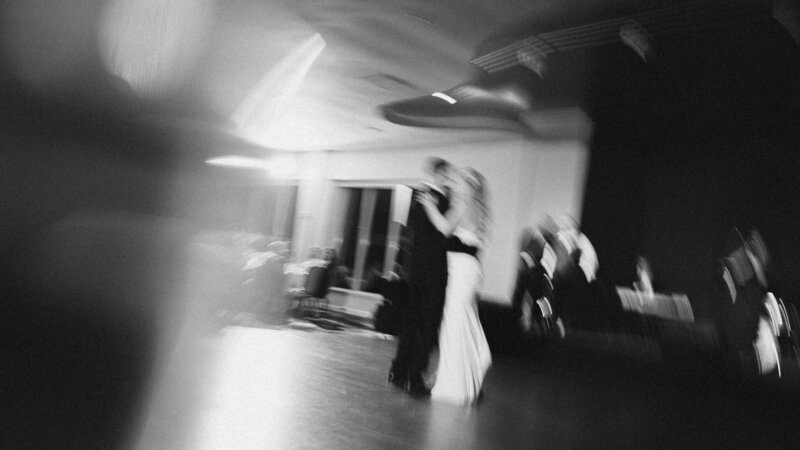 Blurred black-and-white image of newlyweds sharing their first dance