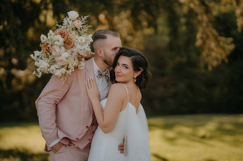Brautpaar mit Brautstrauß im Garten von Aiola im Schloss St. Veit – stilvolle Hochzeit in der Steiermark
