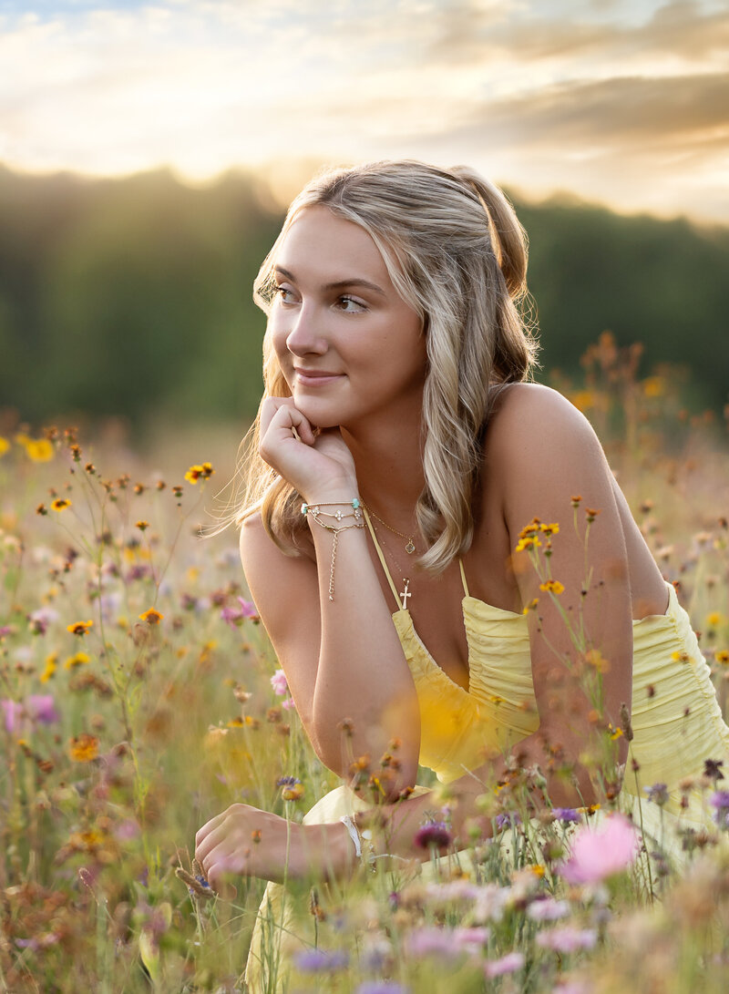 Atlanta senior picture of girl kneeling in a wildflower field in Lawrenceville GA. Jenni Nikki Graduation photographer took this photo.