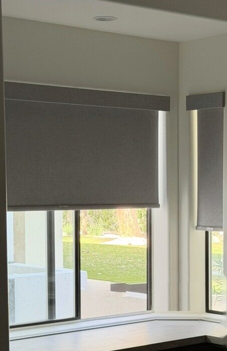 Roller shades with fabric-wrapped valances on narrow corner windows in a Las Vegas home office