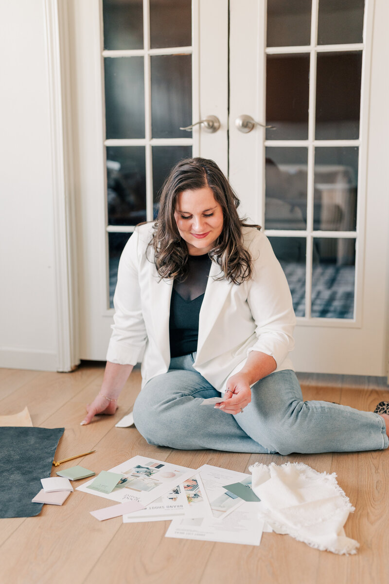 Branding photo of a female creative sorting design samples and mood boards, captured by Zoe Evans Photography for business owners.