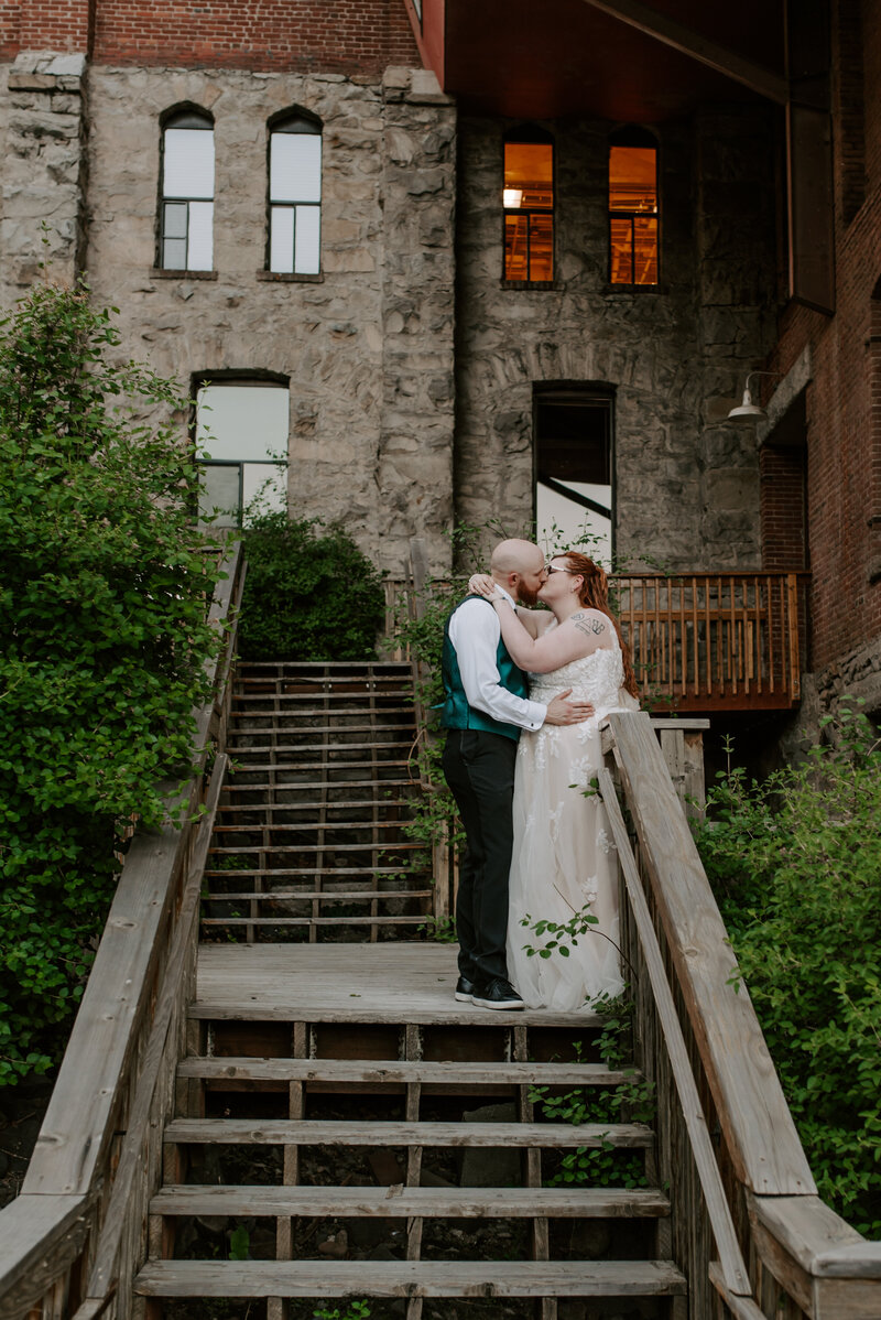 A bride and groom smile at each other in their beautiful wedding venue, Chateau Rive in downtown Spokane, Washington.