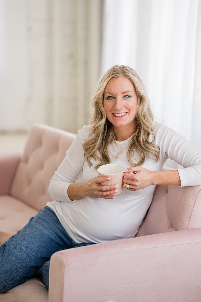 Pregnant mom sitting on couch with coffee