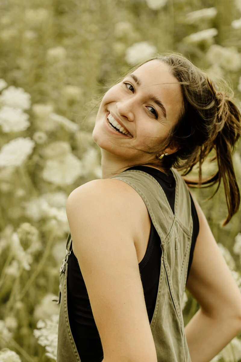 Professional wedding photographer capturing beautiful moments amidst a scenic field backdrop.