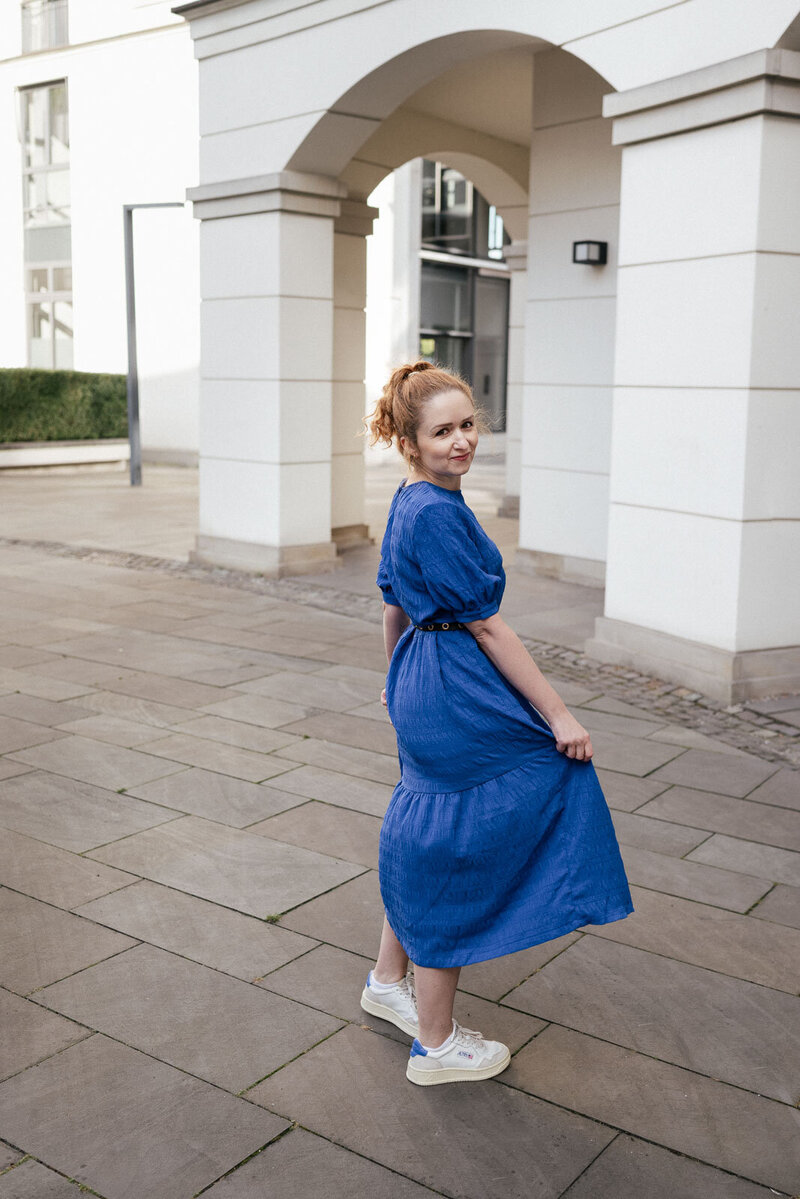 Schauspielerin dreht sich mit ihrem blauen Kleid an einer Location in Hamburg