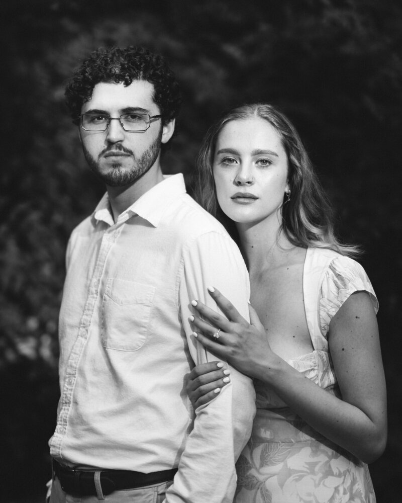 A couple standing in a grassy area about to kiss