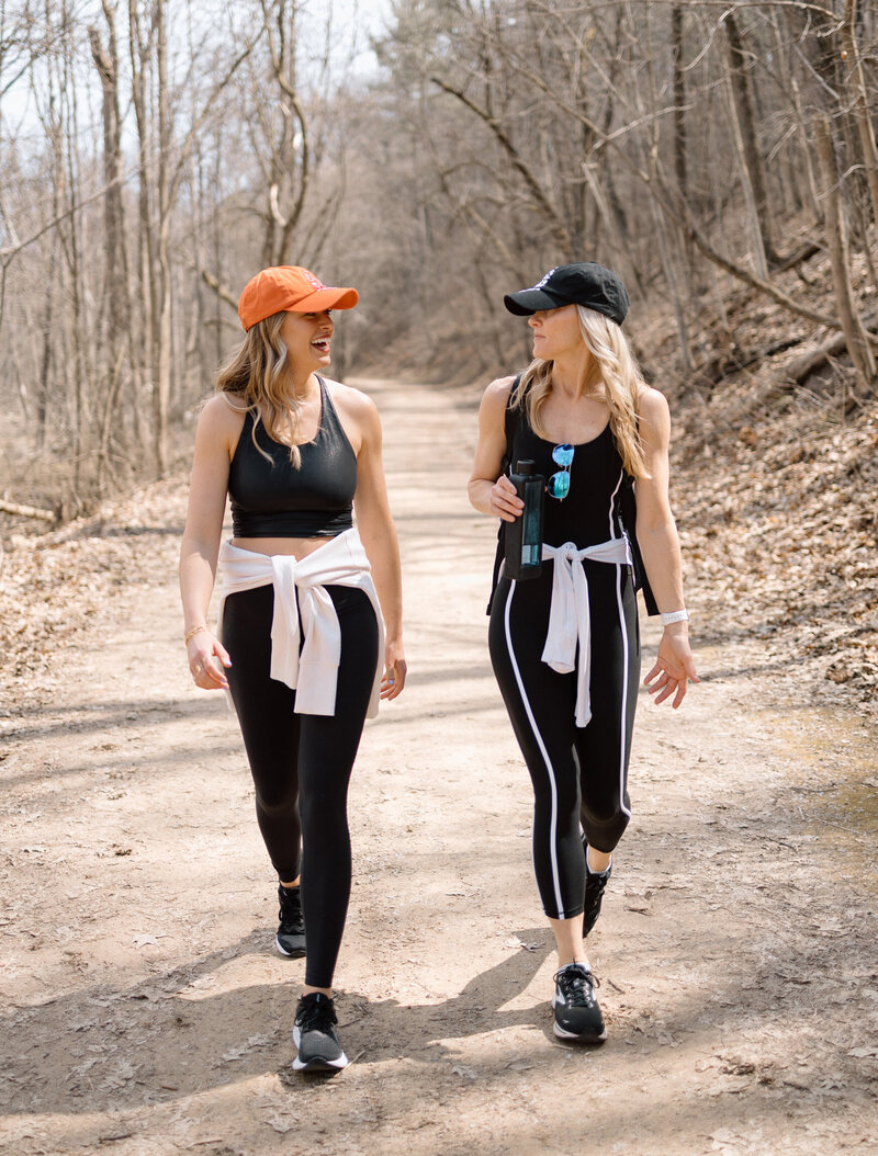 Stacie and Kayla hiking on a dirt trail in the woods