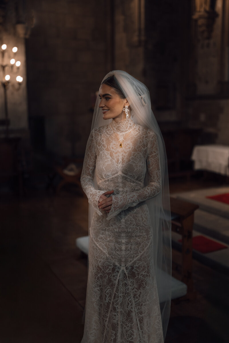 bride illuminated by golden sunlight inside her wedding ceremony at st etheldreda's chuch london