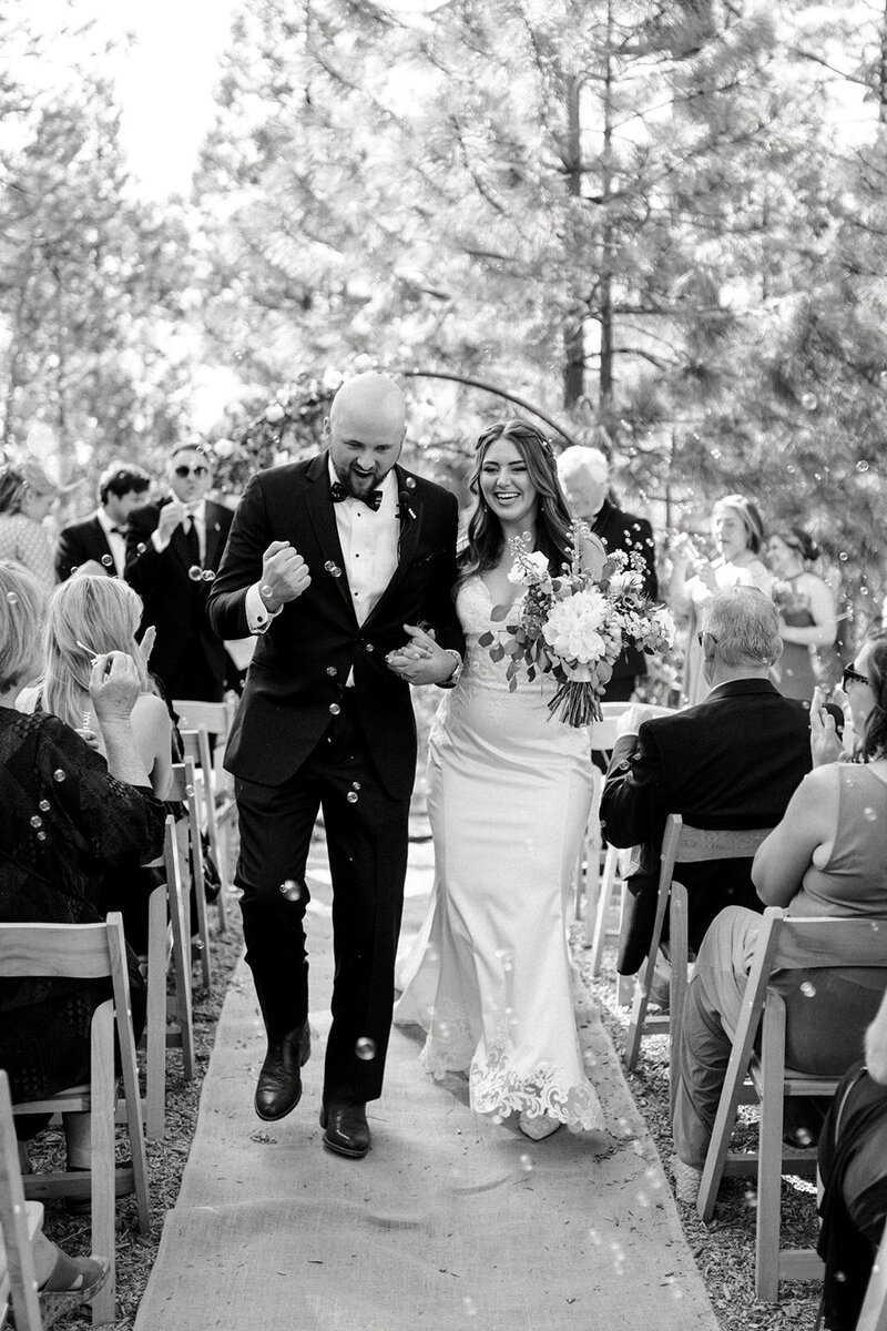 Tiffany Longeway Photography captures a joyful and triumphant moment as the newlyweds walk down the aisle at The Highlands Estate in Cloverdale, California. Surrounded by the natural beauty of the estate and the happiness of their guests, this image reflects the intimate and celebratory atmosphere, ideal for couples seeking a picturesque and heartfelt venue for their wedding celebration.
