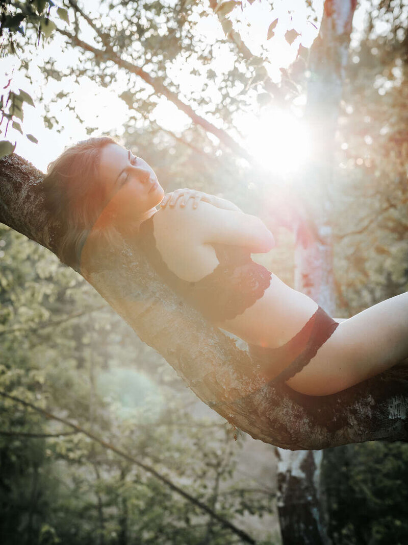 Sensual boudoir shot of a woman in lingerie, outdoor session in a natural setting