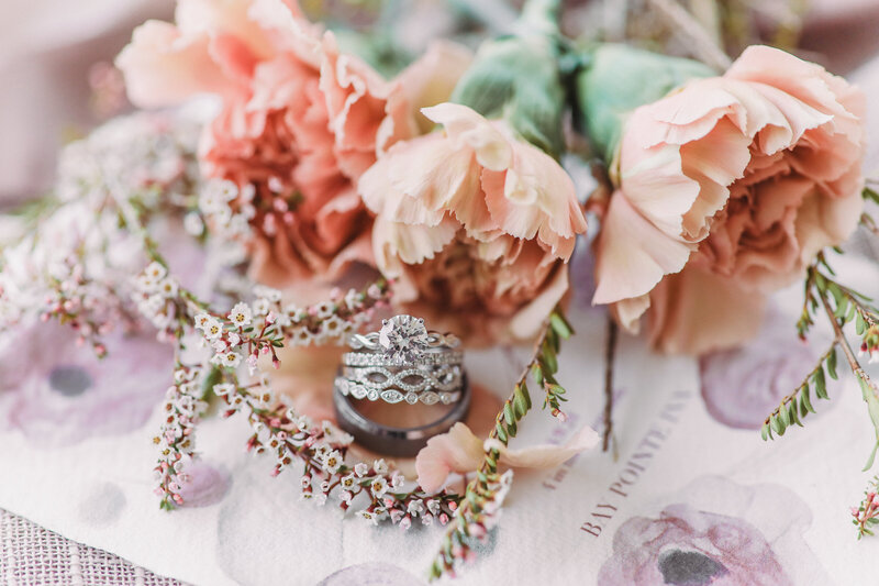 stacked wedding rings staged with blush florals