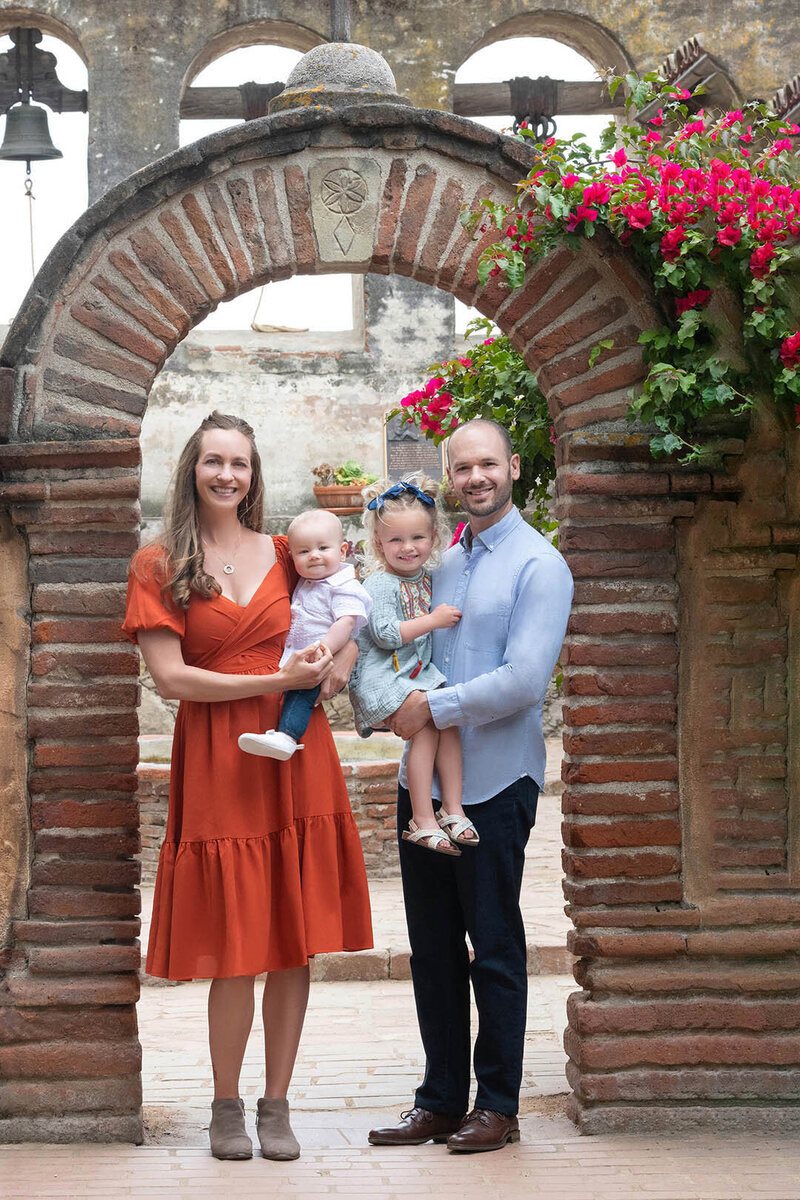 Images from an Orange County Family Photographer hang above a couch