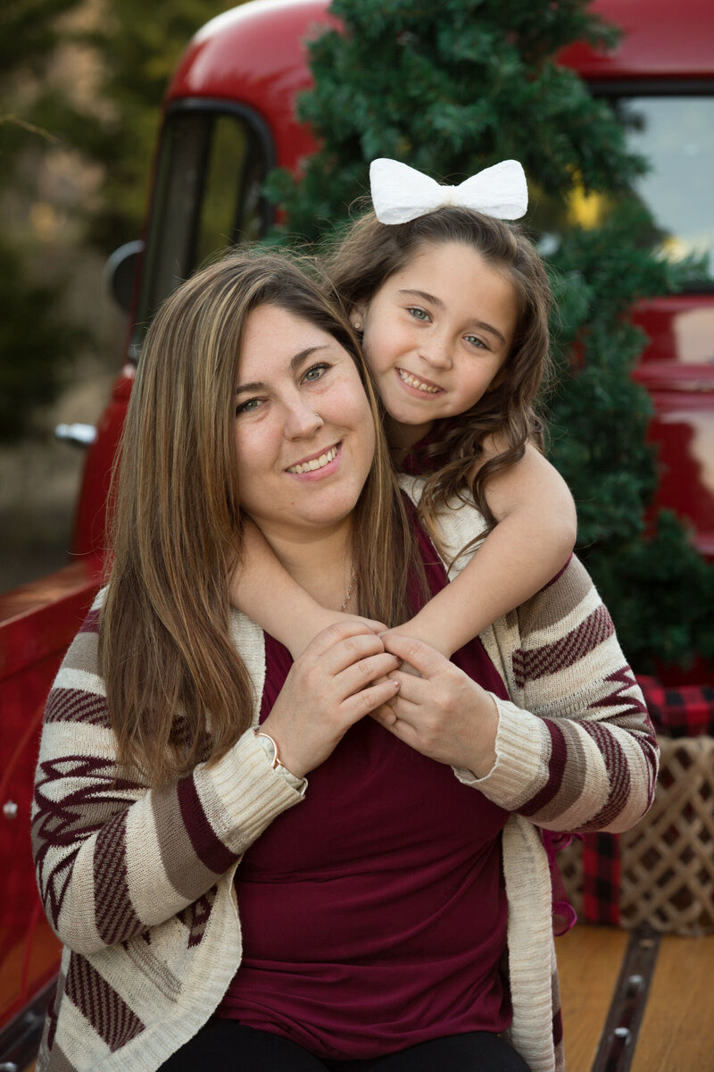 girl-with-arms-around-mom-in-vintage-red-truck