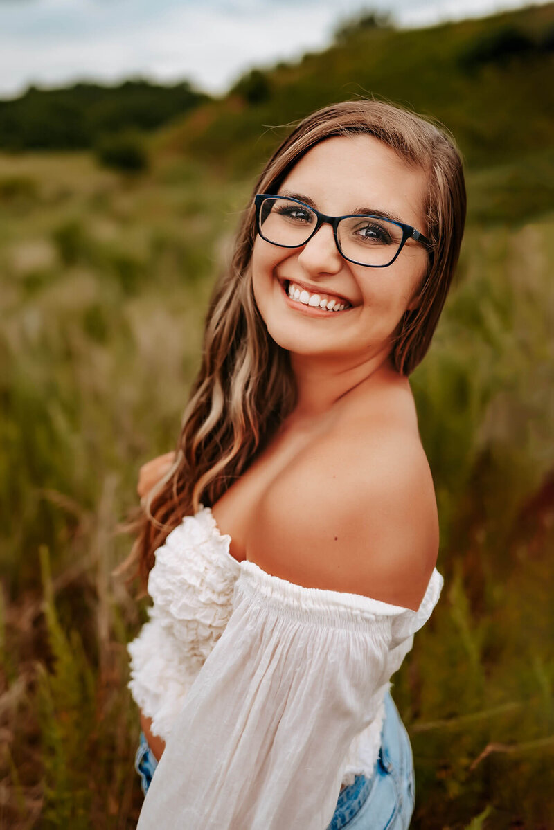 Springfield MO photographer Jessica Kennedy of The XO Photography standing in field smiling