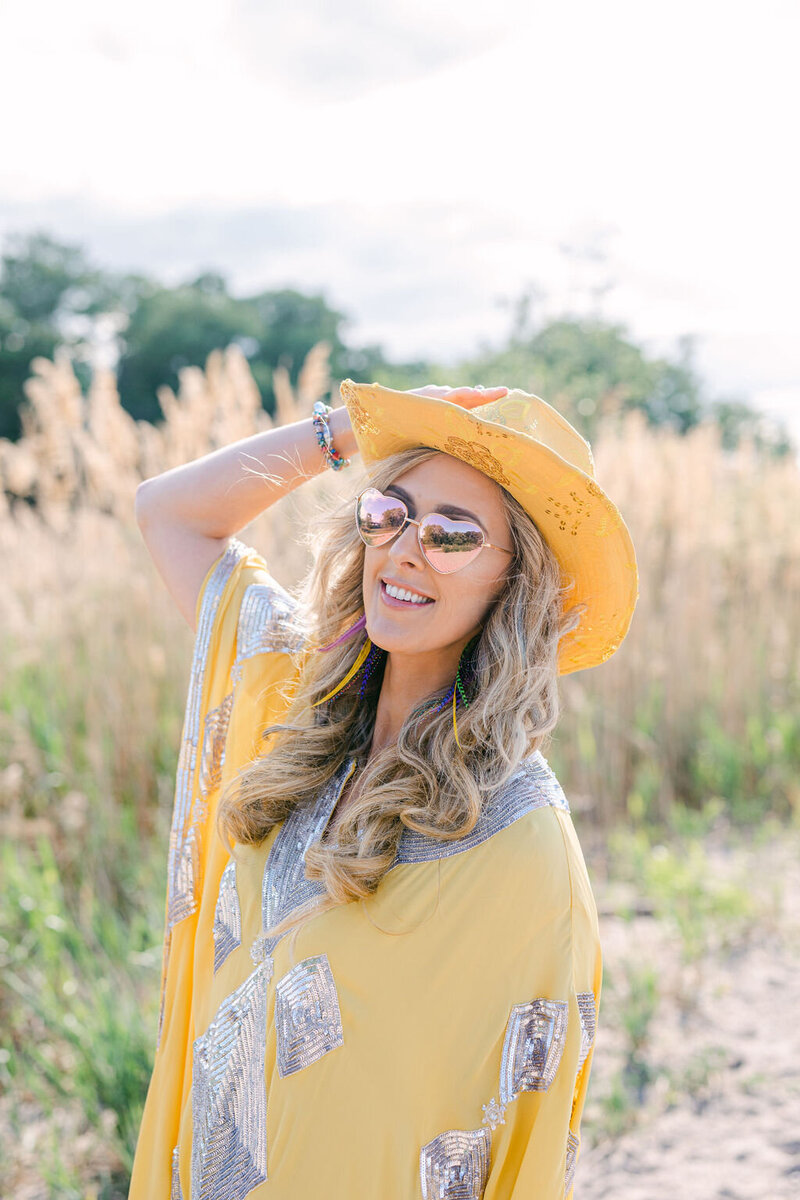 woman in sunglasses and a yellow dress with hat
