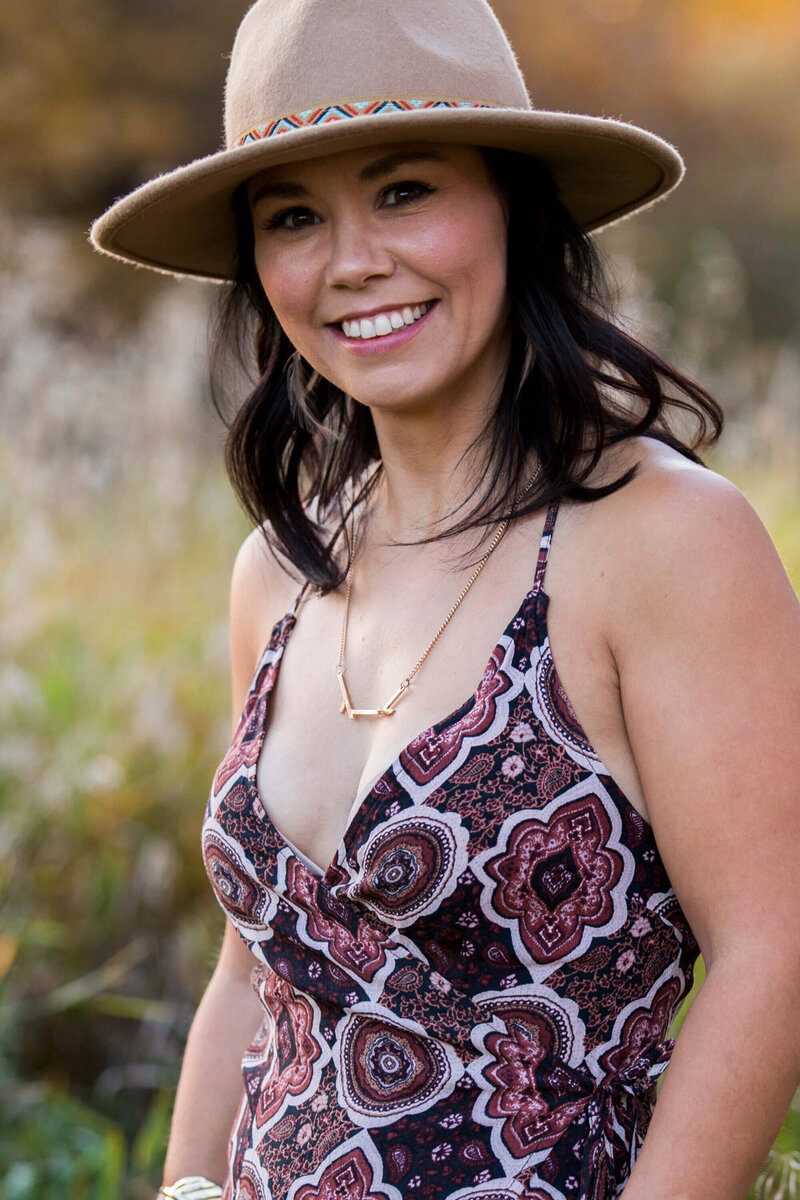 woman smiling at camera with tan hat