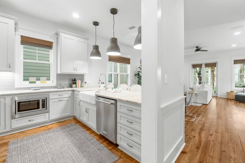 Modern kitchen view and white staircase in the Tangerine Dream beach rental near Santa Rosa Beach.
