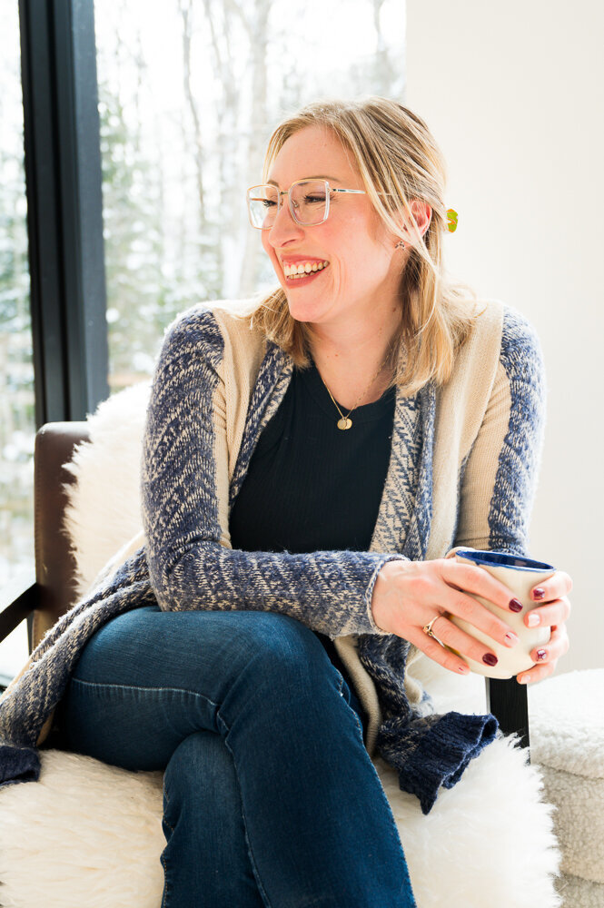 A therapist in Ontario, Canada, sits on a chair, holding a cup of coffee, creating a warm and inviting atmosphere.