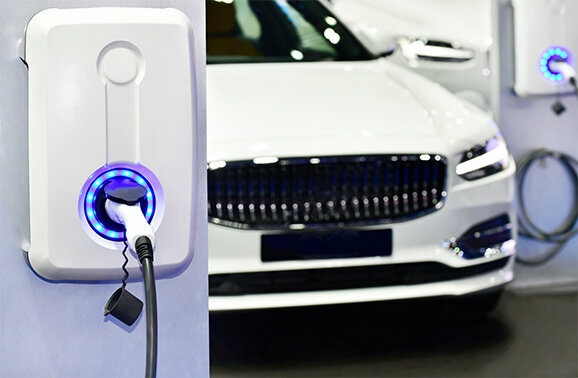 white electric vehicle charging with additional charging station installed on wall nearby