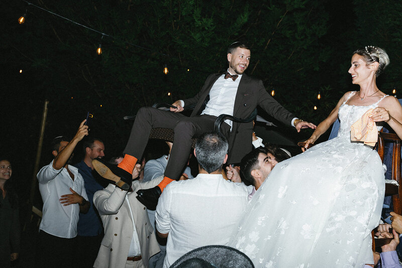 bride and groom being lifted for Hora dance