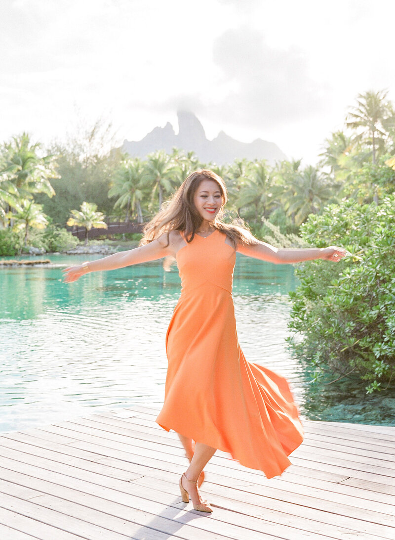 Woman dancing with orange dress in the St Regis Bora Bora