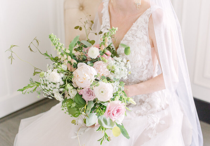A Colorado bride carries a bouquet of pink and white flowers at her wedding.