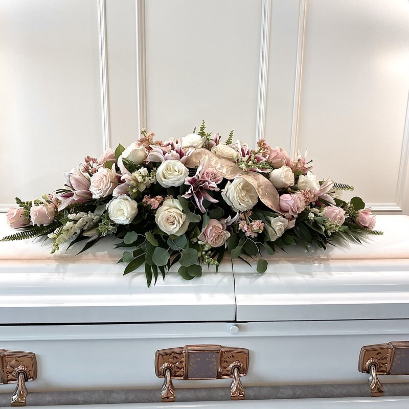 beautiful pink and white casket arrangement at white pine funeral home